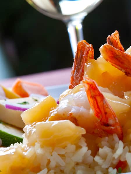 A plate of sautéed vegetables and shrimp served over rice.