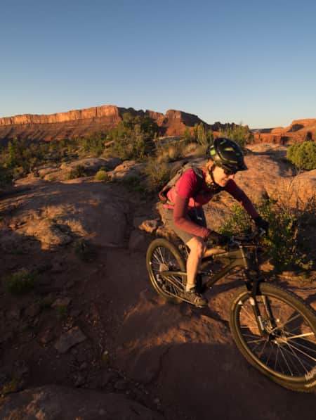 A woman biking on a flat slab of rock.
