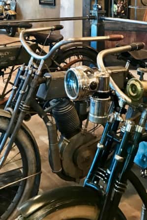 Vintage motorcycles displayed in a museum setting.