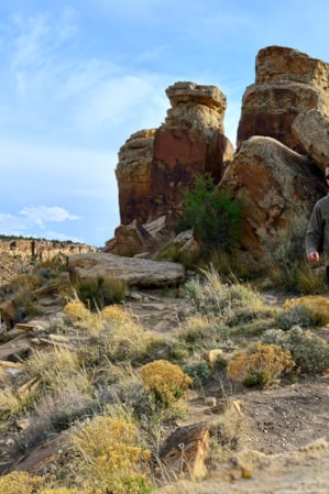 A man hiking on a trail in the desert during the day.