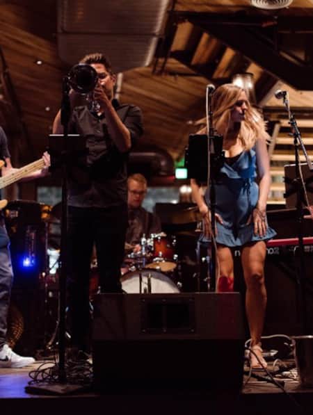 A band performing on stage in a dimly lit bar.