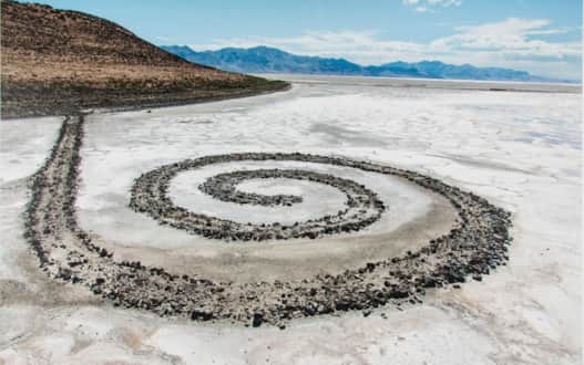 The black rocks of the path lead you westward across the dry playa
