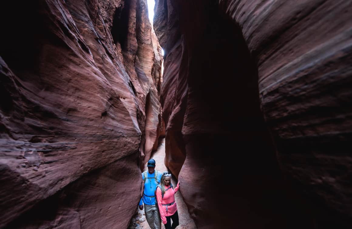 An alcove and desert varnish in the opening of Wire Pass to Buckskin, where the ground is still muddy from a recent storm.