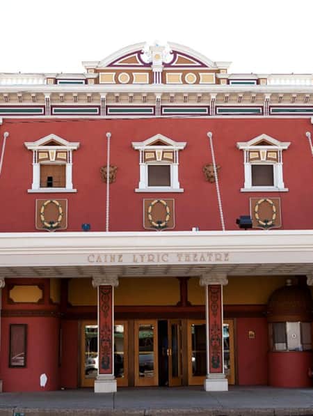 A historical building with decorative finishes, featuring the name 'Caine Lyric Theatre'.