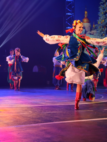 Performers on a stage in costumes, dancing.
