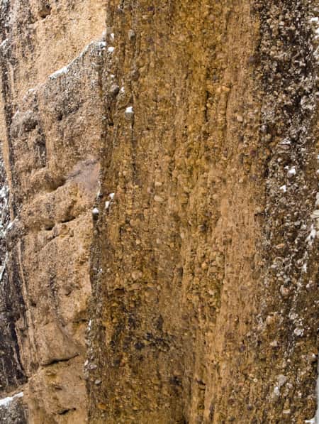 A climber ice climbing on a frozen waterfall.