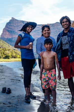 A family standing by a river in a canyon, all smiling.
