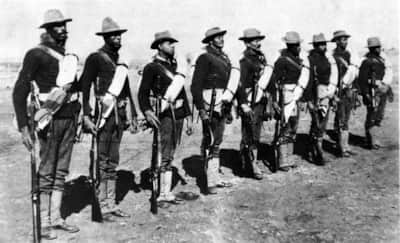 Buffalo Soldiers on campaign duty lined up with the M1873 Springfield Trapdoor Rifle, c. 1893.