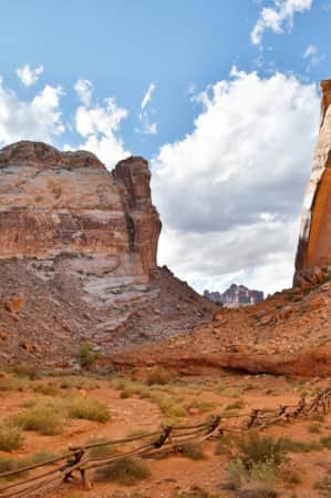 A small canyon of red rock with rocky fields on each side.