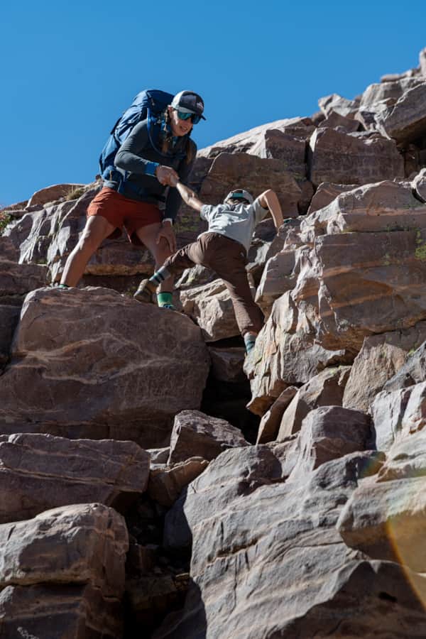 Agnes offers a helping hand while scrambling up a short cliff section on the route to Kings Peak.