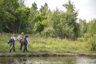 Karlie Haslem, Laura Mascari and Rebeca Reyes Granillo walk along the river during an evening session of fly fishing with friends.
