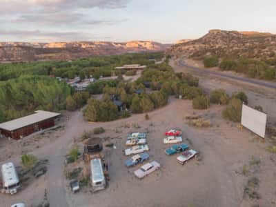 At Ofland Escalante, enjoy a drive-in experience in a pristine '57 Chevy or classic Ford Thunderbird, surrounded by towering red rock formations and an endless expanse of stars.