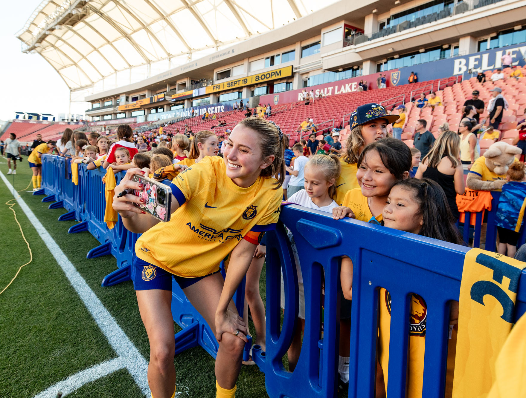 A Utah Royals player poses with a fan. 