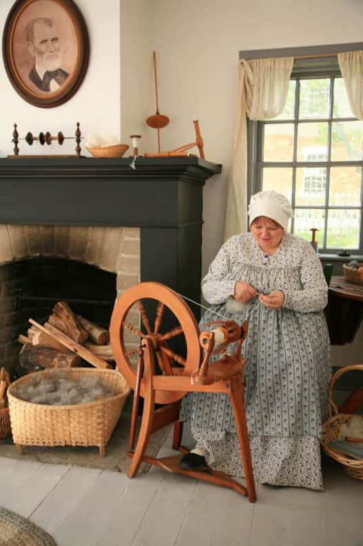 An actor spinning wool at This is the Place Heritage Park.