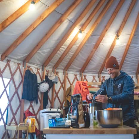 Sam Thackeray prepares breakfast and coffee inside the yurt.