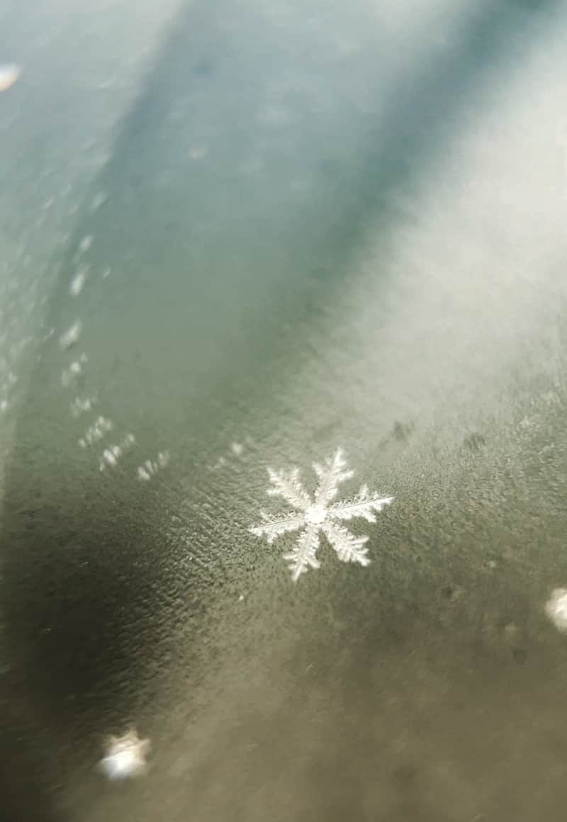 Snowflakes on a glass jar captured with a mobile phone – an example of using the shallow depth of field to draw attention to one of the four snowflakes in the scene.