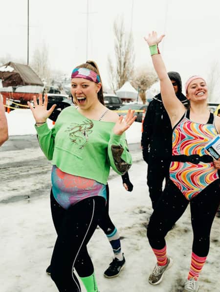 A group of people celebrating outside, with snow and ice on the ground.