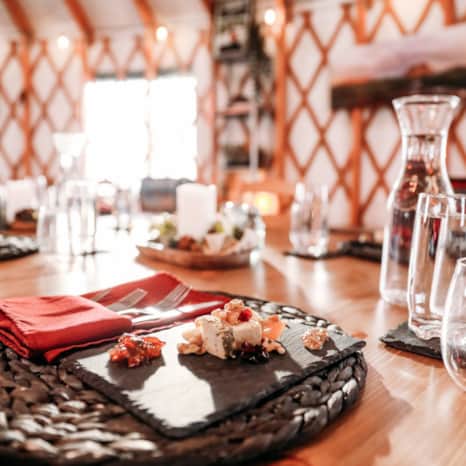 You'll be welcomed into the warmth and comfort of the yurt, where a private, four-course fine dining experience awaits.