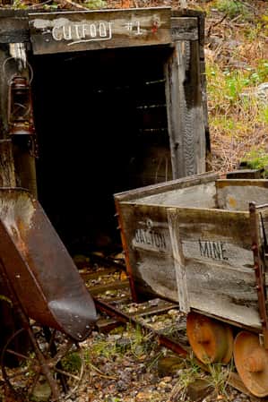 The remains of a mine and a railroad cutting through the side of a hill.
