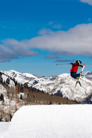 A skier performing a trick in mid-air while coming off a jump.