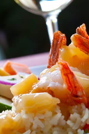 A plate of sautéed vegetables and shrimp served over rice.