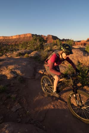 A woman biking on a flat slab of rock.
