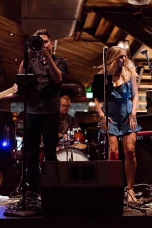 A band performing on stage in a dimly lit bar.