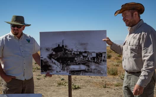 Ray Kelsey (left) and Christopher Merritt (right) use a photo to give evidence of history.