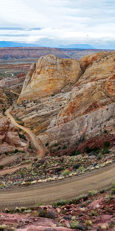 Another backway, the Burr Trail, shares the expansive geological timeline and red rock landscapes of the dinosaur quarry.