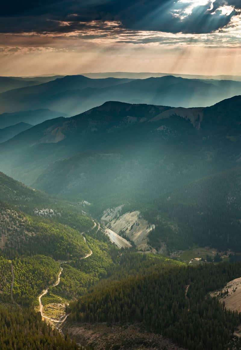Sun rays peaking through the clouds hovering over the Tushar Range.