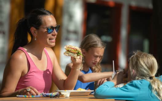 A family enjoying sandwiches from Chuck Wagon General Store & Deli.