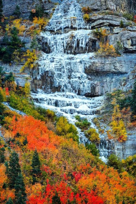 Peak autumnal colors amongst a frozen Stewart Falls.
