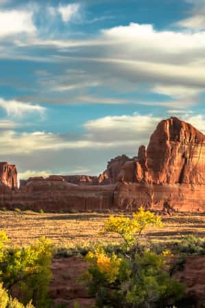 Sunlight illuminating the features of the red rock at Courthouse Wash in Arches National Park.