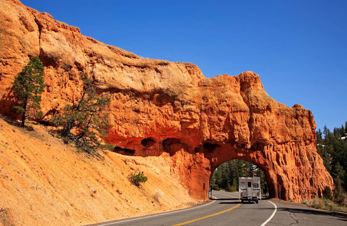 A truck-camper passes through a small tunnel along Scenic Byway 12 in Red Canyon.