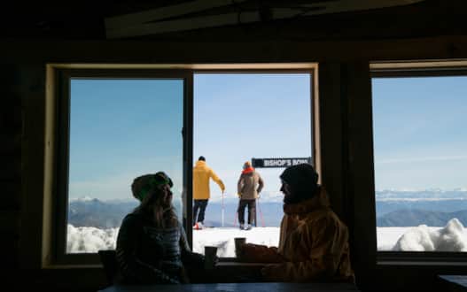 Skiers in the backdrop look out over Bishop's Bowl, Robert Redford's favorite run known for its evolution from spacious to tight slalom turns.