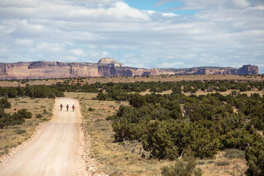 Where sagebrush and sparse juniper trees meets humongous sandstone cliffs.