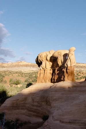A scenic landscape of sparse vegetation, and various red rock formations.