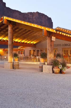 A venue with an awning lit up by twinkle lights, set in front of a large rock formation.