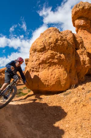 Mountain biker on a trail at Thunder Mountain, smiling and making a quick turn.