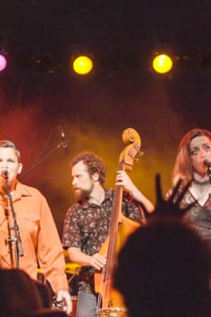Four members of a band preforming on stage.