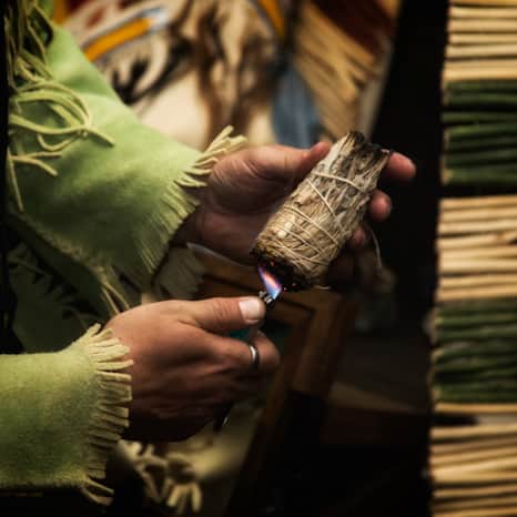 A Shoshone tribal member burning sage and sweetgrass.