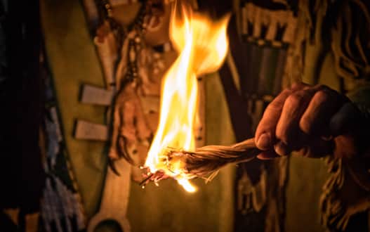 A Shoshone tribal member burning sage and sweetgrass.