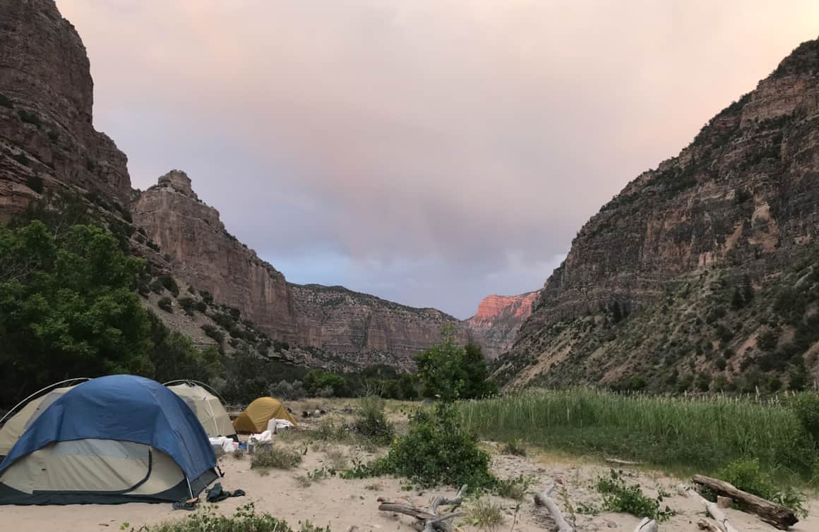 Camping on the sandy beach, the band of sun on the cliffs slowly turns dark.