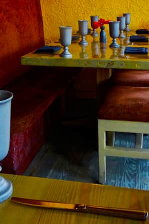 Wooden dining tables with napkins and silverware, and fabric-lined chairs at the Painted Pony Restaurant.