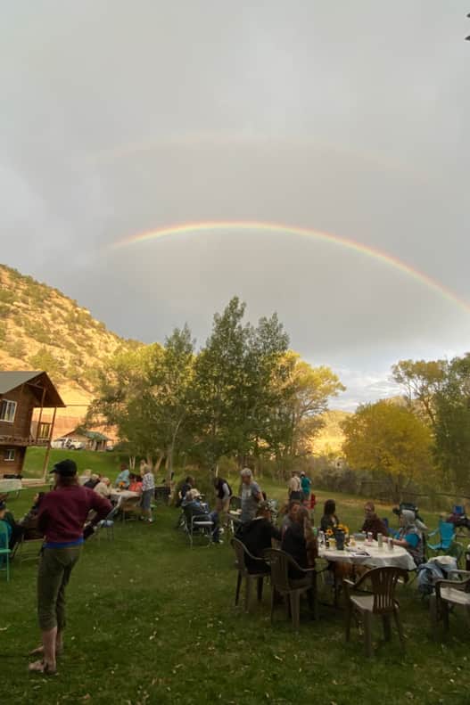 A double rainbow arcs overhead — as if on cue.