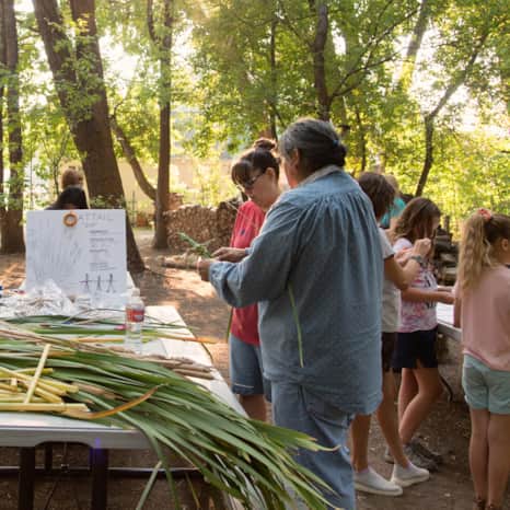 Event participants learn to craft traditional Native corn husk dolls.
