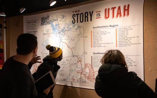 Festival attendees looking closely at a Utah map showing film locations throughout the state.