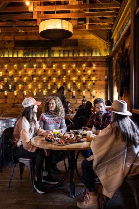 High West Saloon features 19th-century Western charm and contemporary elegance, evident in its rich wooden elements, historic photographs and unique lighting fixtures.