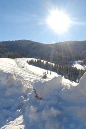 Snowmobile tracks and a snowy view of Bear Lake.