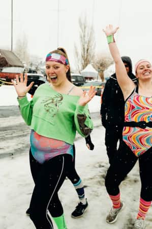 A group of people celebrating outside, with snow and ice on the ground.